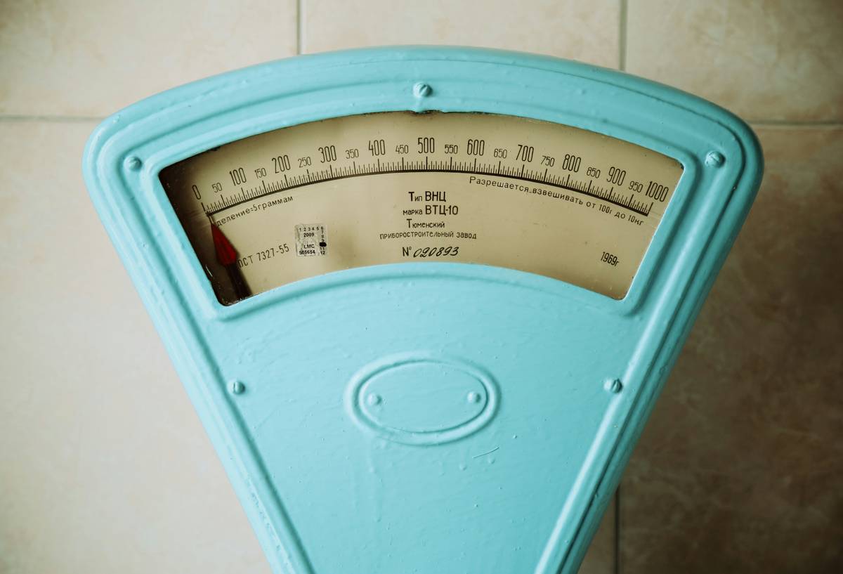 Goal Success Metrics: Woman journaling non-scale victories like energy levels and mood in a wellness tracker